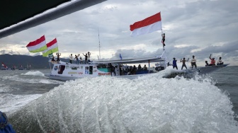 Sejumlah warga berada di atas kapal nelayan berhias bendera berkeliling saat mengikuti pesta nelayan di kawasan Pantai Kasiwa, Mamuju, Sulawesi Barat, minggu (5/10/2025). [ANTARA FOTO/Akbar Tado/foc]