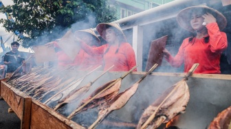 Sejumlah warga mengasapi ikan cakalang fufu saat mengikuti Festival Nyao Fufu di Kelurahan Dufa-Dufa Kampung Nelayan di Ternate, Maluku Utara, Senin (6/10/2025). [ANTARA FOTO/Andri Saputra/YU]