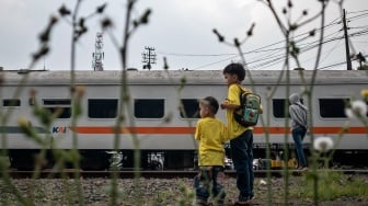 Warga menyaksikan rangkaian kereta api (KA) melintas di Stasiun Cimahi, Kota Cimahi, Jawa Barat, Sabtu (11/10/2025). [ANTARA FOTO/Abdan Syakura/rwa]