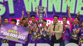 Ketua Umum Federasi Futsal Indonesia Michael Sianipar (ketiga kanan) didampingi Chief Marketing Officer XLSMART Alfons Bosch Sansa (kedua kanan) menyerahkan piala kepada tim futsal putra SMK Nusantara Jakarta Barat sebagai juara pertama AXIS Nation Cup (ANC) 2025 di Istora Senayan, Jakarta, Sabtu (11/10/2025). [Suara.com/Alfian Winanto]