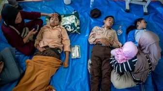 Orang tua mendampingi anaknya yang diduga keracunan hidangan makan bergizi gratis (MBG) di SMPN 1 Cisarua, Cisarua, Kabupaten Bandung Barat, Jawa Barat, Selasa (14/10/2025). [ANTARA FOTO/Abdan Syakura/nym]