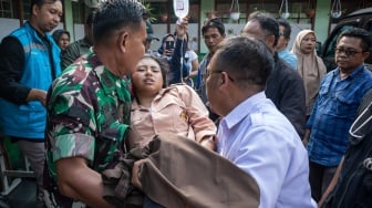 Anggota TNI bersama petugas kesehatan mengevakuasi siswa yang diduga keracunan hidangan makan bergizi gratis (MBG) di SMPN 1 Cisarua, Cisarua, Kabupaten Bandung Barat, Jawa Barat, Selasa (14/10/2025). [ANTARA FOTO/Abdan Syakura/nym]
