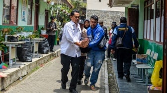 Petugas menggendong siswa korban yang diduga keracunan hidangan Makan Bergizi Gratis (MBG) di posko penanganan keracunan MBG di SMPN 1 Cisarua, Kabupaten Bandung Barat, Jawa Barat, Rabu (15/10/2025). [ANTARA FOTO/Raisan Al Farisi/rwa]