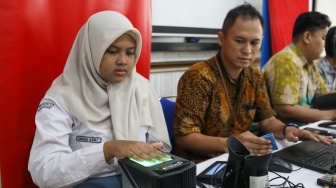 Petugas dari Dinas Kependudukan dan Pencatatan Sipil (Disdukcapil) DKI Jakarta melakukan perekaman e-KTP di SMKN 32 Jakarta, Kamis (16/10/2025). [Suara.com/Alfian Winanto]
