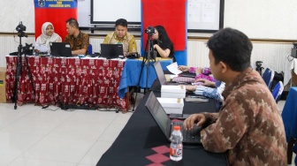 Petugas dari Dinas Kependudukan dan Pencatatan Sipil (Disdukcapil) DKI Jakarta melakukan perekaman e-KTP di SMKN 32 Jakarta, Kamis (16/10/2025). [Suara.com/Alfian Winanto]