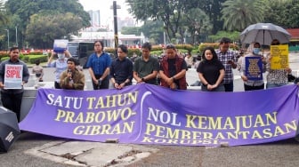 Massa dari Koalisi Bersihkan Indonesia (KBI) saat menggelar aksi simbolik di Taman Pandang Istana, Jakarta, Senin (20/10/2025). [Suara.com/Alfian Winanto]