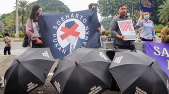 Massa dari Koalisi Bersihkan Indonesia (KBI) saat menggelar aksi simbolik di Taman Pandang Istana, Jakarta, Senin (20/10/2025). [Suara.com/Alfian Winanto]
