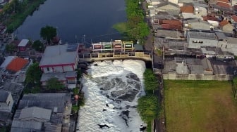 Foto udara gumpalan busa putih mengapung di permukaan sungai di Kalisari Damen, Surabaya, Jawa Timur, Senin (20/10/2025). [ANTARA FOTO/Didik Suhartono/YU]