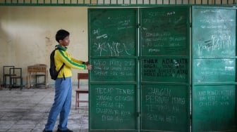 Siswa menarik pintu pembatas kelas di SMK Al-Anshor, Legok, Kabupaten Tangerang, Banten, Selasa (21/10/2025). [ANTARA FOTO/Putra M. Akbar/rwa]