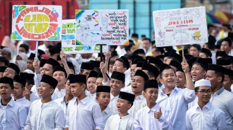 Sejumlah santri membawa poster saat mengikuti apel Hari Santri Nasional 2025 di Taman Elektrik, Kota Tangerang, Banten, Rabu (22/10/2025). [ANTARA FOTO/Putra M. Akbar/nym]