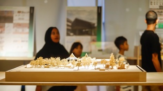Pengunjung mengamati instalasi maket bangunan dalam Jakarta Architecture Festival 2025 di Blok M Hub, Jakarta, Kamis (23/10/2025). [Suara.com/Alfian Winanto]