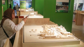 Pengunjung mengamati instalasi maket bangunan dalam Jakarta Architecture Festival 2025 di Blok M Hub, Jakarta, Kamis (23/10/2025). [Suara.com/Alfian Winanto]