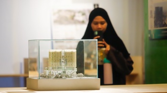 Pengunjung mengamati instalasi maket bangunan dalam Jakarta Architecture Festival 2025 di Blok M Hub, Jakarta, Kamis (23/10/2025). [Suara.com/Alfian Winanto]