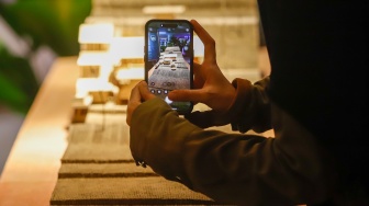 Pengunjung mengamati instalasi maket bangunan dalam Jakarta Architecture Festival 2025 di Blok M Hub, Jakarta, Kamis (23/10/2025). [Suara.com/Alfian Winanto]
