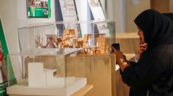 Pengunjung mengamati instalasi maket bangunan dalam Jakarta Architecture Festival 2025 di Blok M Hub, Jakarta, Kamis (23/10/2025). [Suara.com/Alfian Winanto]