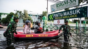Personel Babinsa Koramil 06/Genuk menggunakan perahu karet untuk mengangkut pasien saat banjir melanda jalur utama Pantura Semarang - Surabaya di Jalan Kaligawe Raya, Semarang, Jawa Tengah, Jumat (24/10/2025). [ANTARA FOTO/Aprillio Akbar/YU]