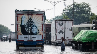 Warga mengatur arus lalu lintas saat banjir menggenangi jalur utama pantura Semarang-Surabaya di Jalan Kaligawe Raya, Semarang, Jawa Tengah, Jumat (24/10/2025). [ANTARA FOTO/Aprillio Akbar/YU]