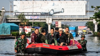 Personel Babinsa Koramil 06/Genuk menggunakan perahu karet untuk mengangkut pasien dan tenaga kesehatan saat banjir melanda jalur utama Pantura Semarang - Surabaya di Jalan Kaligawe Raya, Semarang, Jawa Tengah, Jumat (24/10/2025). [ANTARA FOTO/Aprillio Akbar/YU]