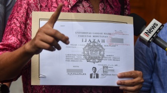 Pengamat Kebijakan Publik Bonatua Silalahi memperlihatkan salinan foto copy ijazah presiden ke-7 RI Joko Widodo yang dilegalisir ketika mendaftar sebagai capres pada Pemilu 2014 di Komisi Pemilihan Umum (KPU), Jakarta, Jumat (24/10/2025). [ANTARA FOTO/Indrianto Eko Suwarso/foc]