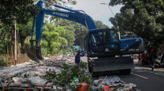 Petugas membongkar kios menggunakan eskavator di Pasar Hewan Barito, Jakarta, Senin (27/10/2025). [Suara.com/Alfian Winanto]