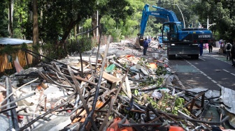 Petugas membongkar kios menggunakan eskavator di Pasar Hewan Barito, Jakarta, Senin (27/10/2025). [Suara.com/Alfian Winanto]