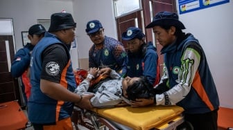 Relawan mengevakuasi siswa yang diduga keracunan hidangan makan bergizi gratis (MBG) untuk menjalani perawatan medis di Poned Cibodas, Lembang, Kabupaten Bandung Barat, Jawa Barat, Rabu (29/10/2025). [ANTARA FOTO/Abdan Syakura/nz]