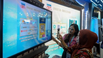 Pengunjung mencoba memindai QRIS Korea Selatan saat Festival Ekonomi dan Keuangan Digital (FEKDI) x Indonesia Fintech Summit & Expo (IFSE) 2025 di Jakarta, Kamis (30/10/2025). [ANTARA FOTO/Putra M. Akbar/YU]