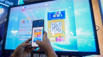 Pengunjung mencoba memindai QRIS Korea Selatan saat Festival Ekonomi dan Keuangan Digital (FEKDI) x Indonesia Fintech Summit & Expo (IFSE) 2025 di Jakarta, Kamis (30/10/2025). [ANTARA FOTO/Putra M. Akbar/YU]
