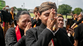 Kerabat dan abdi dalem menempelkan kedua tangannya ketika mengiringi kereta jenazah Raja Keraton Kasunanan Surakarta Hadiningrat Sri Susuhunan Paku Buwana (PB) XIII di Solo, Jawa Tengah, Rabu (5/11/2025). [ANTARA FOTO/Mohammad Ayudha/tom]