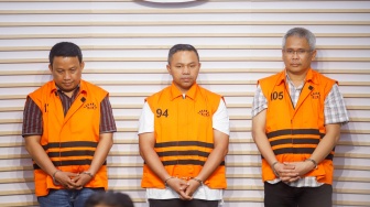 Gubernur Riau Abdul Wahid (tengah) mengenakan rompi oranye khas tahanan KPK usai ditetapkan sebagai tersangka korupsi di Gedung Merah Putih KPK, Jakarta, Rabu (5/11/2025). [Suara.com/Alfian Winanto]