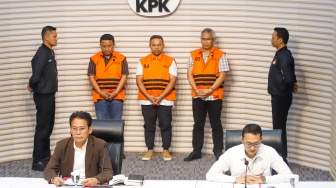 Gubernur Riau Abdul Wahid (tengah) mengenakan rompi oranye khas tahanan KPK usai ditetapkan sebagai tersangka korupsi di Gedung Merah Putih KPK, Jakarta, Rabu (5/11/2025). [Suara.com/Alfian Winanto]