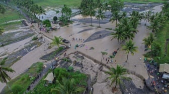 Foto udara warga melintasi lahar hujan Gunung Semeru yang meluap dari Sungai Regoyo di Desa Gondoruso, Kecamatan Pasirian, Lumajang, Jawa Timur, Rabu (5/11/2025). [ANTARA FOTO/Irfan Sumanjaya/nym]