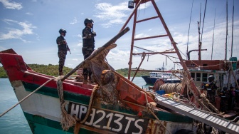 Personel Direktorat Jenderal Pengawasan Sumber Daya Kelautan dan Perikanan (PSDKP) menjaga barang bukti kapal ikan asing (KIA) yang diamankan di Pangkalan PSDKP Batam, Kepulauan Riau, Kamis (6/11/2025). [ANTARA FOTO/Teguh Prihatna/foc]