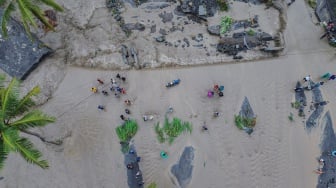Foto udara warga melintasi lahar hujan Gunung Semeru yang meluap dari Sungai Regoyo di Desa Gondoruso, Kecamatan Pasirian, Lumajang, Jawa Timur, Rabu (5/11/2025). [ANTARA FOTO/Irfan Sumanjaya/nym]
