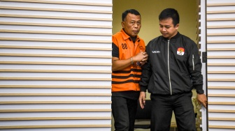 Petugas membawa tersangka selaku Bupati Ponorogo Sugiri Sancoko (kiri) untuk dihadirkan dalam konferensi pers di gedung Merah Putih KPK, Jakarta, Minggu (9/11/2025). [ANTARA FOTO/Muhammad Adimaja/sgd]