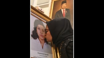 Adik aktivis buruh Marsinah, Wijiyati mencium foto kakaknya usai mengikuti upacara pemberian gelar pahlawan kepada Marsinah dan sembilan tokoh lainnya di Istana Negara, Jakarta, Senin (10/11/2025). [ANTARA FOTO/Aditya Pradana Putra/nz]