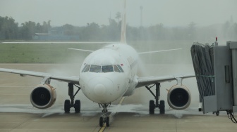 Pesawat Super Air Jet mendapatkan guyuran air saat tradisi water salute atau penyambutan pesawat saat penerbangan perdana di Bandara Dhoho Kediri, Jawa Timur, Senin (10/11/2025). [ANTARA FOTO/Prasetia Fauzani/bar]