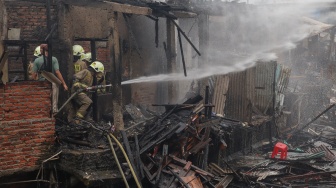 Petugas Dinas Penanggulangan Kebakaran dan Penyelamatan (Gulkarmat) melakukan pemadaman api di permukiman padat penduduk Tambora, Jakarta, Selasa (11/11/2025). [ANTARA FOTO/Ika Maryani/agr] 
