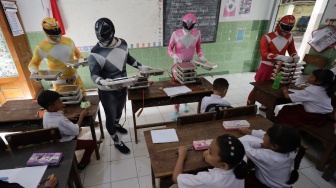 Sejumlah petugas berkostum Power Rangers mengantar Makan Bergizi Gratis (MBG) di SD Negeri Tempurejo 1, Kota Kediri, Jawa Timur, Kamis (13/11/2025). [ANTARA FOTO/Prasetia Fauzani/bar]
