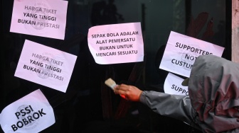 Suporter Timnas Indonesia yang tergabung dalam Ultras Garuda menempelkan kertas aspirasi saat aksi tuntut revolusi total PSSI di Jalan Gerbang Pemuda, Jakarta, Jumat (14/11/2025). [ANTARA FOTO/Fauzan/bar]