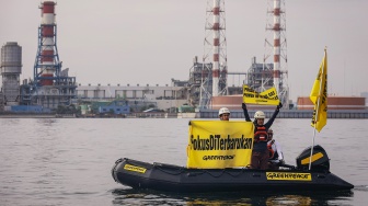 Aktivis Greenpeace membentangkan spanduk saat menggelar aksi damai di kawasan Pembangkit Listrik Tenaga Gas Uap (PLTGU) Muara Karang di Jakarta, Selasa (18/11/2025). [ANTARA FOTO/Dhemas Reviyanto/YU]