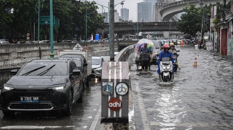 Kendaraan menerobos banjir di Jalan Terusan H. R. Rasuna Said, Jakarta, Selasa (18/11/2025). [ANTARA FOTO/Sulthony Hasanuddin/nym]
