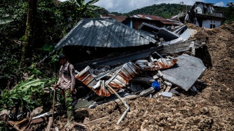 Relawan berdiri di samping rumah warga yang roboh terdampak bencana tanah longsor di Dusun Situkung, Desa Pandanarum, Kecamatan Pandanarum, Kabupaten Banjarnegara, Jawa Tengah, Selasa (18/11/2025). [ANTARA FOTO/Aprillio Akbar/YU]