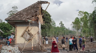 Warga melintasi perkampungan yang terdampak erupsi Gunung Semeru di Desa Supiturang, Lumajang, Jawa Timur, Kamis (20/11/2025). [ANTARA FOTO/Irfan Sumanjaya/nz]
