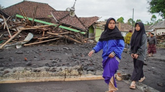 Warga melintasi kondisi mushalla yang terdampak erupsi Gunung Semeru di Desa Supiturang, Lumajang, Jawa Timur, Kamis (20/11/2025). [ANTARA FOTO/Irfan Sumanjaya/nz]