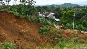 Petugas Badan Penanggulangan Bencana Daerah (BPBD) menggunakan alat berat menyingkirkan material yang menimbun jalan akibat longsor di Desa Wagir Kidul, Pulung, Ponorogo, Jawa Timur, Kamis (20/11/2025). [ANTARA FOTO/Siswowidodo/nz]