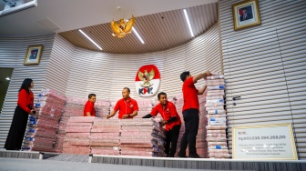Petugas menyusun tumpukan aset hasil rampasan senilai kurang lebih Rp 883 miliar (ditampilkan Rp 300 miliar) diserahkan KPK kepada PT. Taspen (Persero) di Gedung Merah Putih KPK, Jakarta, Kamis (20/11/2025). [Suara.com/Alfian Winanto]