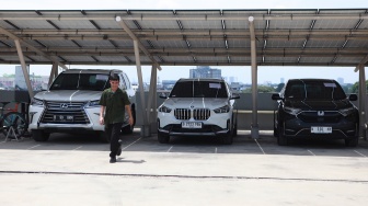 Petugas berjalan di dekat barang bukti kendaraan hasil sitaan yang akan dilelang di Rumah Penyimpanan Benda Sitaan Negara (Rupbasan) Komisi Pemberantasan Korupsi di Cawang, Jakarta, Rabu (26/11/2025). [ANTARA FOTO/Reno Esnir/sgd/tom]