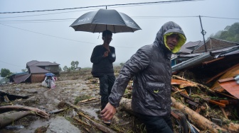 Warga melintasi material longsor di Toboh Tangah, Nagari Malalak Timur, Agam, Sumatera Barat, Kamis (27/11/2025). [ANTARA FOTO/Iggoy el Fitra/YU]