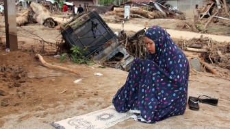 Warga menunaikan shalat di area rumah yang rusak akibat banjir bandang di Desa Aek Garoga, Kecamatan Batang Toru, Kabupaten Tapanuli Selatan, Sumatera Utara, Minggu (30/11/2025). [ANTARA FOTO/Yudi Manar/nz]